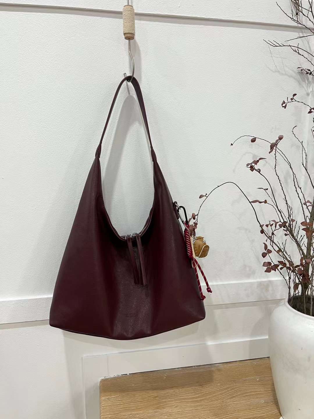 حقيبة يد نسائية متوسطة الحجم بذراع عريض باللون العنابي مع دلاية متعددة - KSA