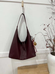 حقيبة يد نسائية متوسطة الحجم بذراع عريض باللون العنابي مع دلاية متعددة - KSA