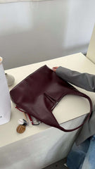 حقيبة يد نسائية متوسطة الحجم بذراع عريض باللون العنابي مع دلاية متعددة - KSA